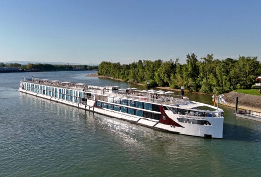 Ein Flussschiff das in Ufernähe fährt